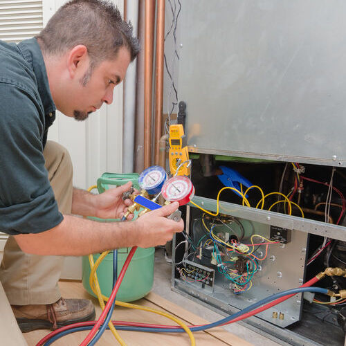 HVAC Technician Uses Gauges to Test for Leaks.